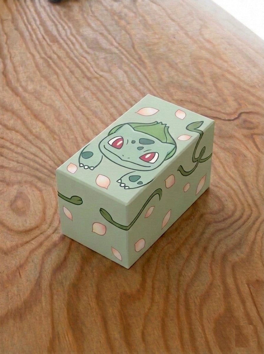 Mystery Box Pokémon 80+1 Più Carte: scatola rigida verde a tema Bulbasaur con 80 carte Pokémon originali in italiano senza doppioni, 1 Ultra Rara e 100 bustine protettive Atomic